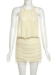 Mannequin wearing a cream-colored dress with a halter neck and fringe details on a white background