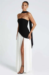 Woman wearing a black and white dress with a high slit on a white background