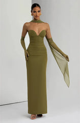 Woman wearing a green evening gown with matching gloves against a white background