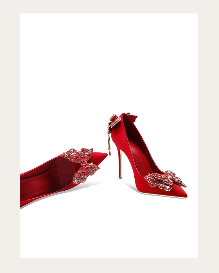 Red high-heeled shoes with decorative elements on a white background