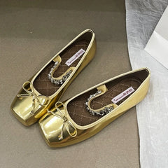 Gold square toe ballet flats with a bow and crystal embellishment