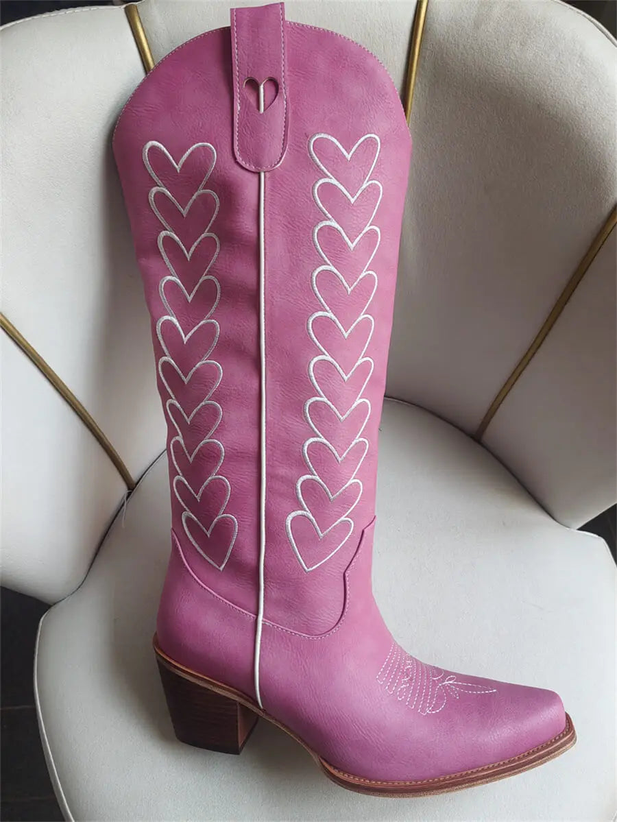 Pink cowboy boot with heart designs on a white chair