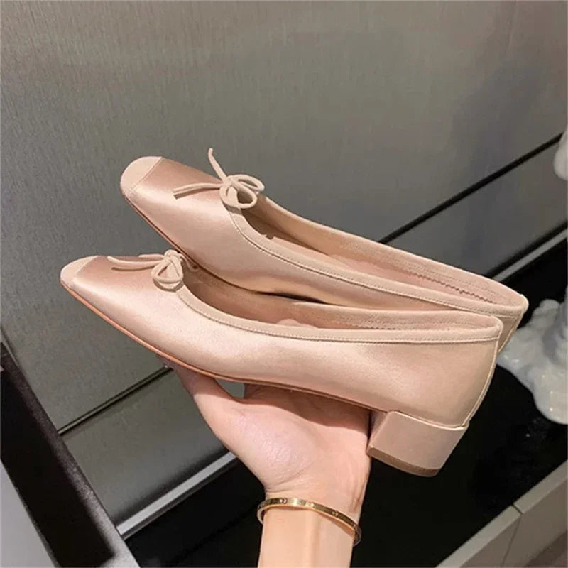 Silk bowknot square toe ballet flats in champagne held in hand