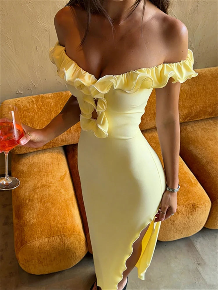 Woman in a yellow off-shoulder dress holding a drink against an orange couch.