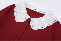 Close-up of the embroidered lace collar on a burgundy knit dress.
