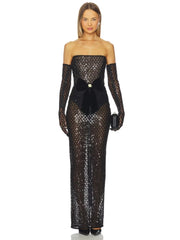 Woman wearing a black sequin gown with long sleeves on a white background