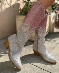 Silver glittery cowboy boots with wooden soles on a concrete surface.