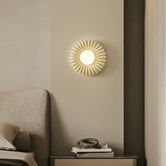 A Parisian-inspired round wall sconce with a milk white glass shade, casting a romantic glow above a bed. B