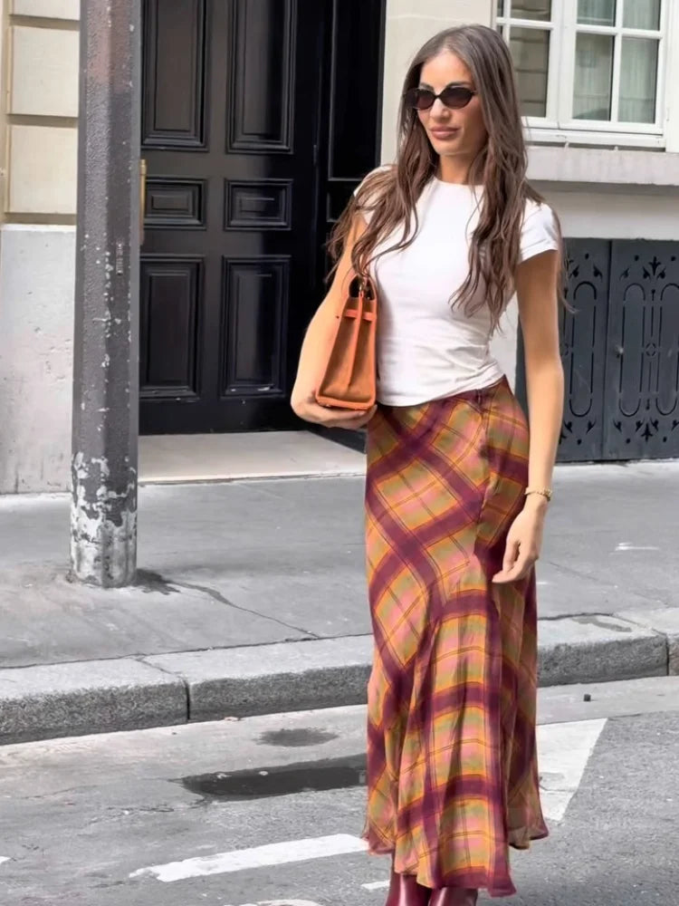 Irregular hem plaid maxi skirt worn by a woman standing on a street.