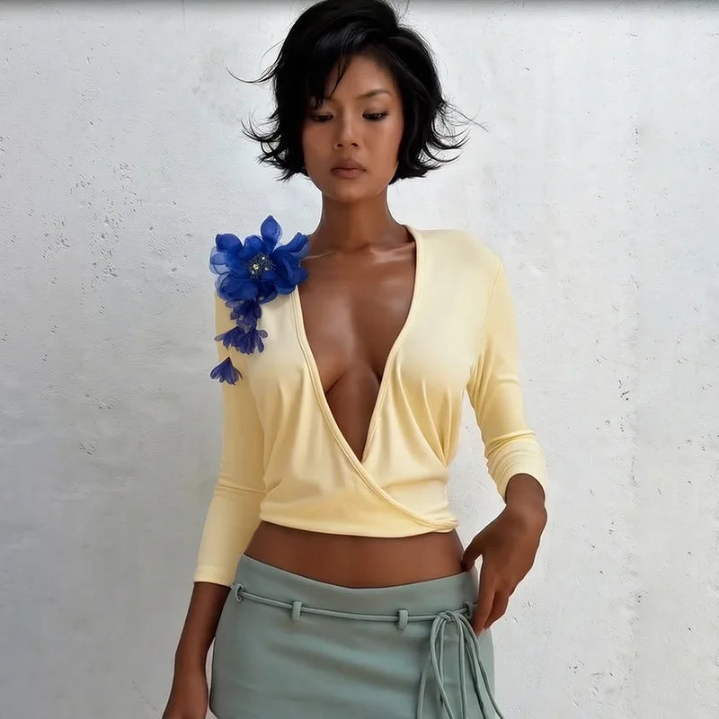 Light yellow wrap top with floral shoulder embellishment.