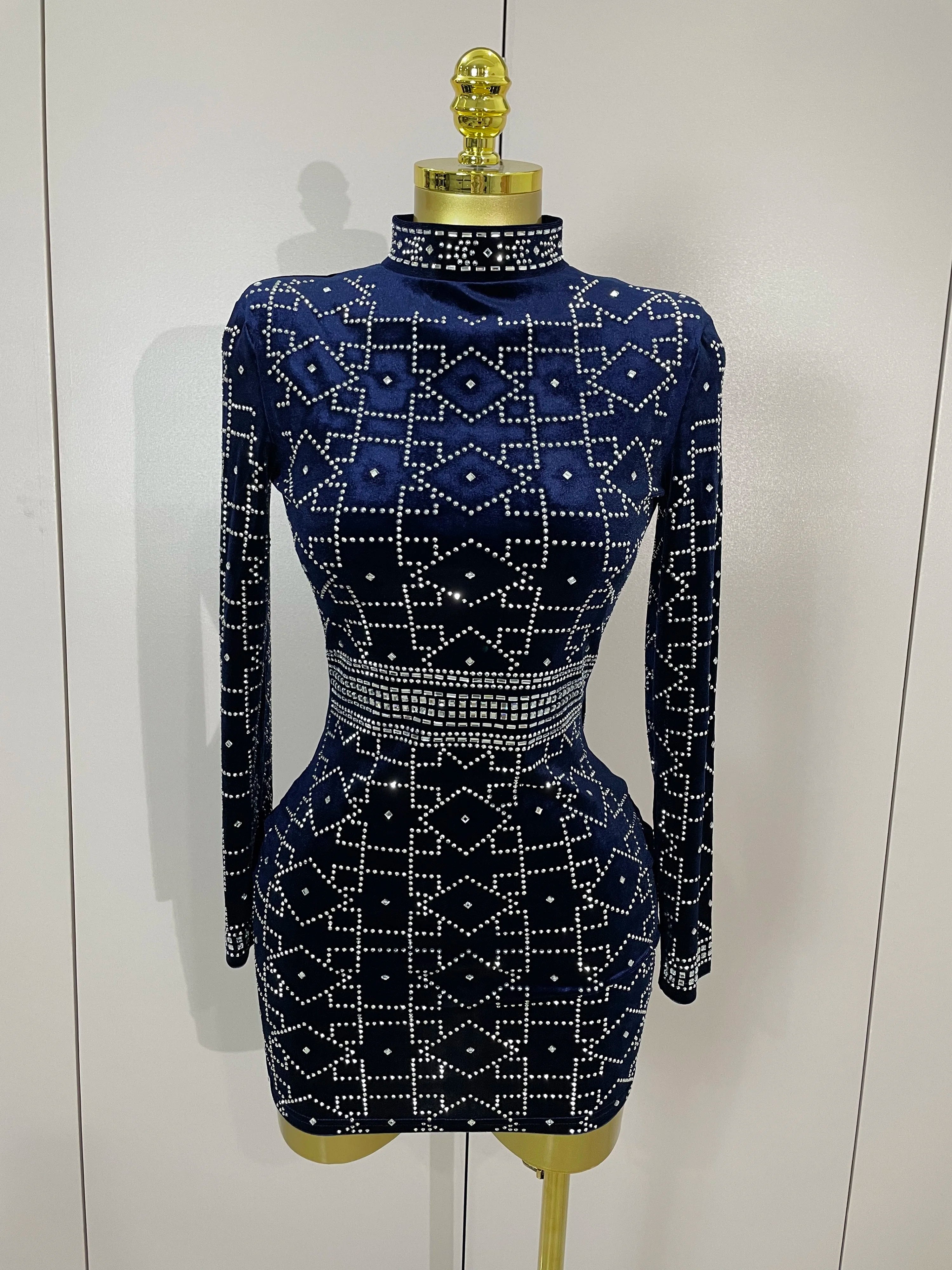 Navy blue dress with white geometric pattern on a mannequin against a white background
