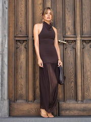 Woman in a brown dress standing in front of a wooden door