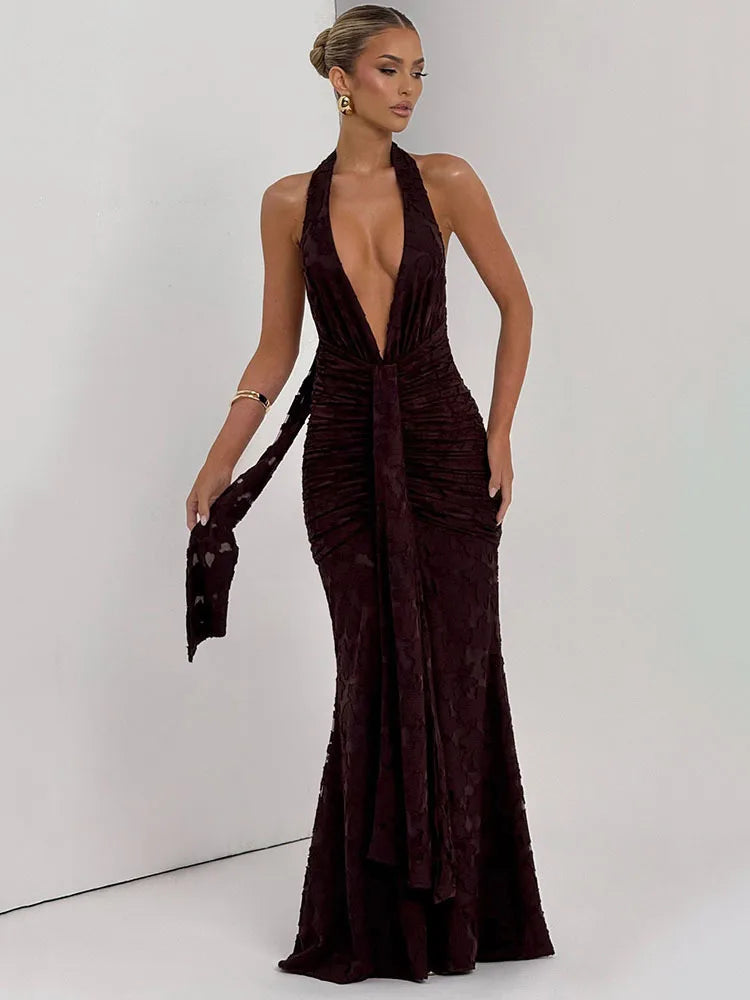 Woman wearing a deep neckline brown evening gown against a white background
