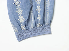 Detail of embroidered cuff on blue puff sleeve blouse