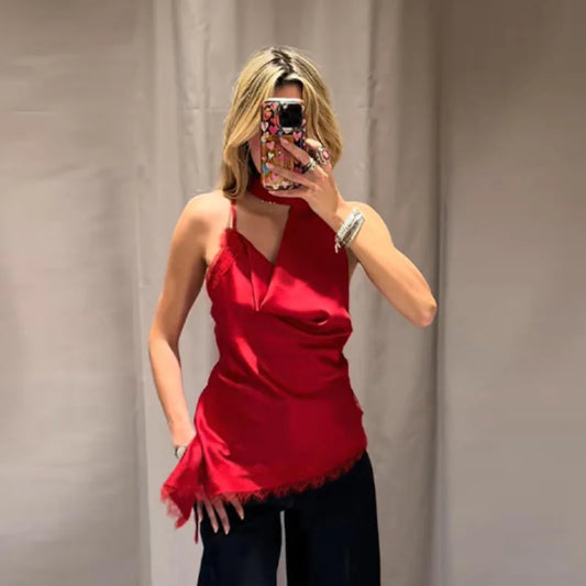 Person wearing a red top and black pants against a plain background