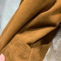 Close-up of brown fabric texture with a hand holding it