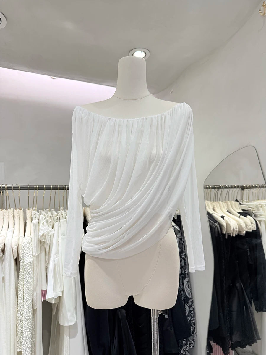 White off-shoulder top on a mannequin in a clothing store setting