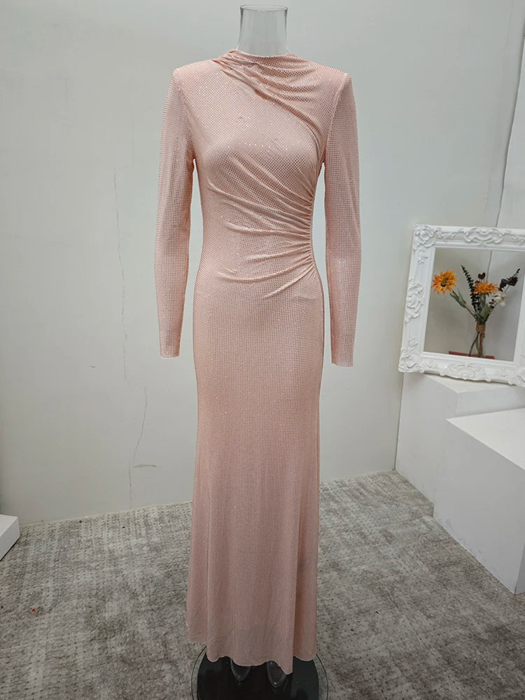 An apricot long-sleeve dress on a mannequin against a white wall.