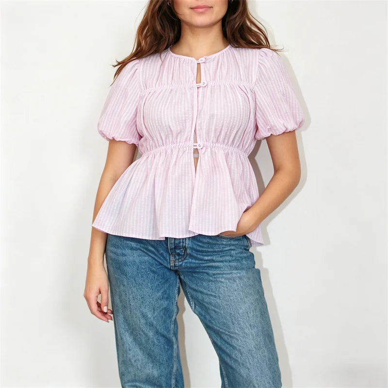 Model wearing a pink striped puff sleeve button-front peplum top with blue jeans
