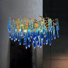 Blue glass chandelier with gold accents against a dark background