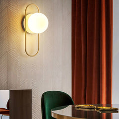 An LED 7W G9 Bulb Indoor Wall Sconce with a primary image showing a round gold  -colored sconce in a modern style above a chair , table and red curtain.