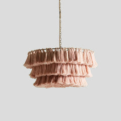 Close-up of the Fela pendant light showcasing its intricate tassel details and warm glow. Pink A