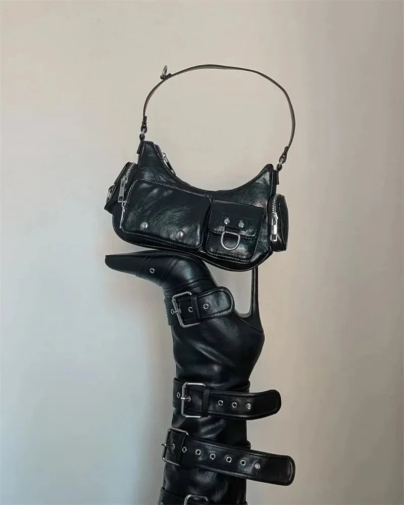Black leather outfit with a bag and boots on a plain background