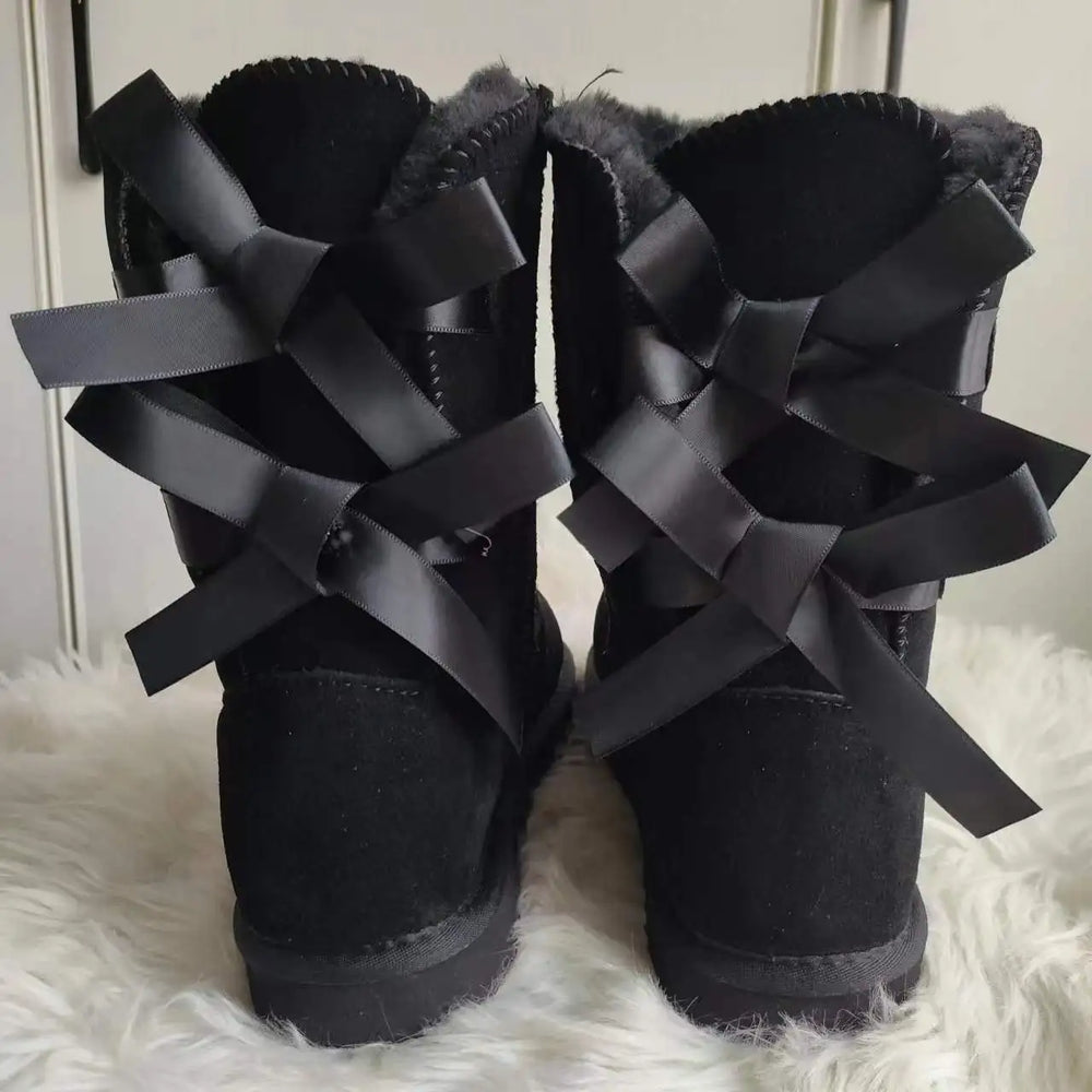 Back view of black plush snow boots with ribbon bows