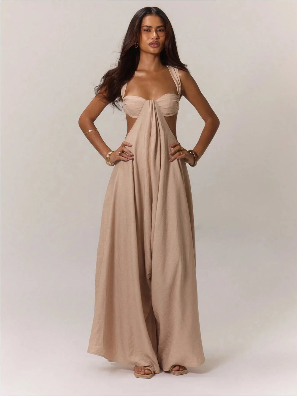Woman wearing a beige jumpsuit on a plain background