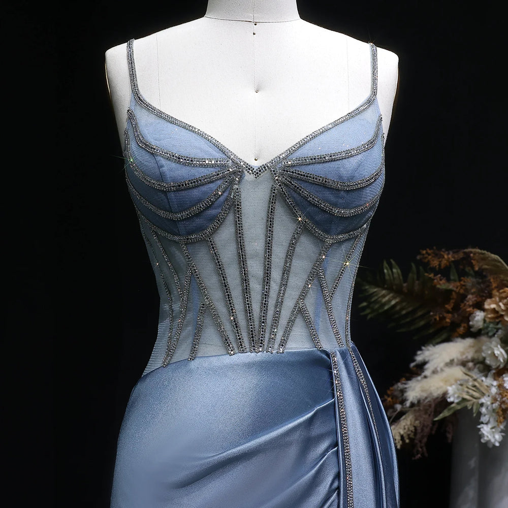 Blue evening gown with intricate detailing on a mannequin against a dark background