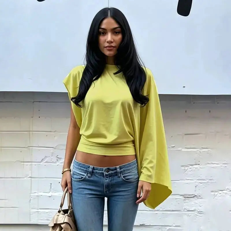 Model wearing an asymmetrical drop-shoulder knit top in light green