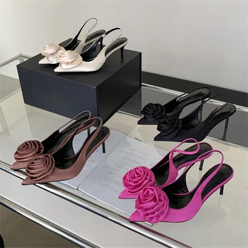 High-heeled shoes with floral designs on a reflective surface