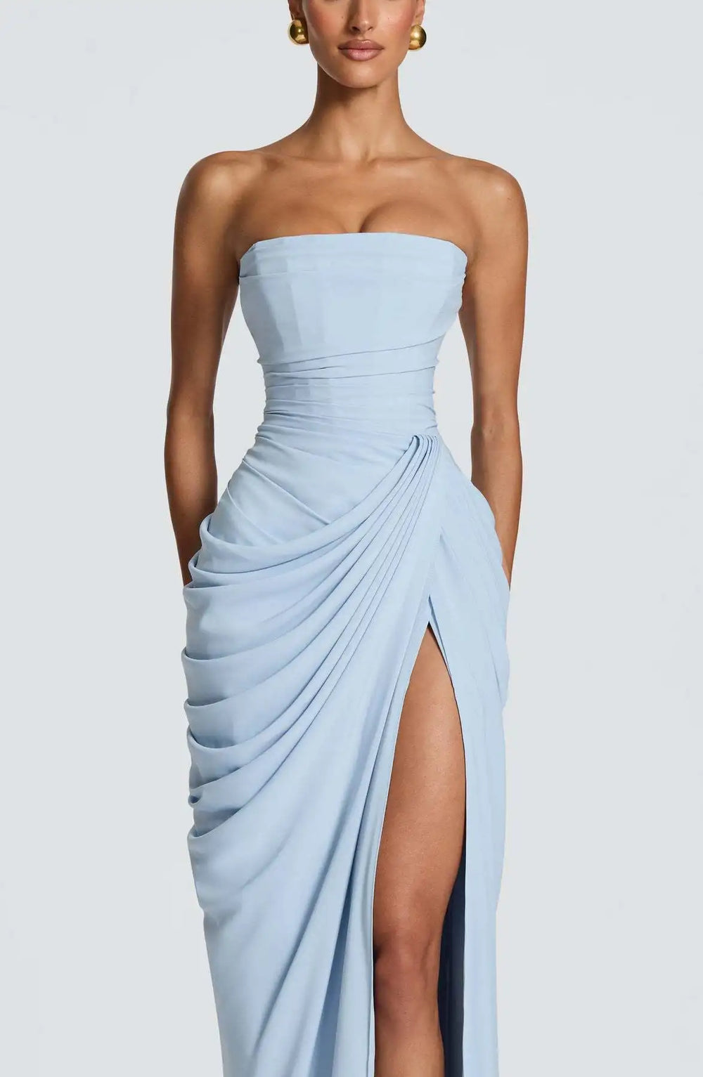 Light blue strapless gown with a high slit on a plain background