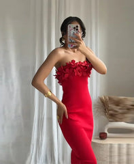 Red strapless dress with floral details worn by a person, against a neutral background.