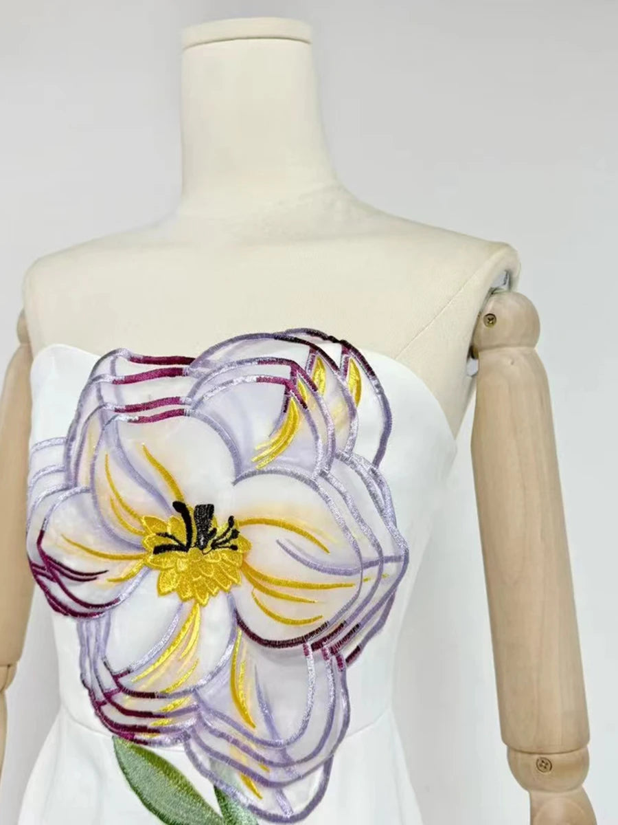 White dress with a large floral design on a mannequin against a white background