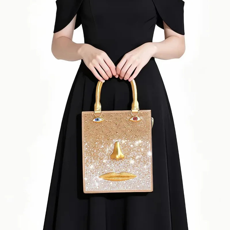 Sculptural face embellished bag with gold-tone nose and lips, and jewel-toned eye accents.