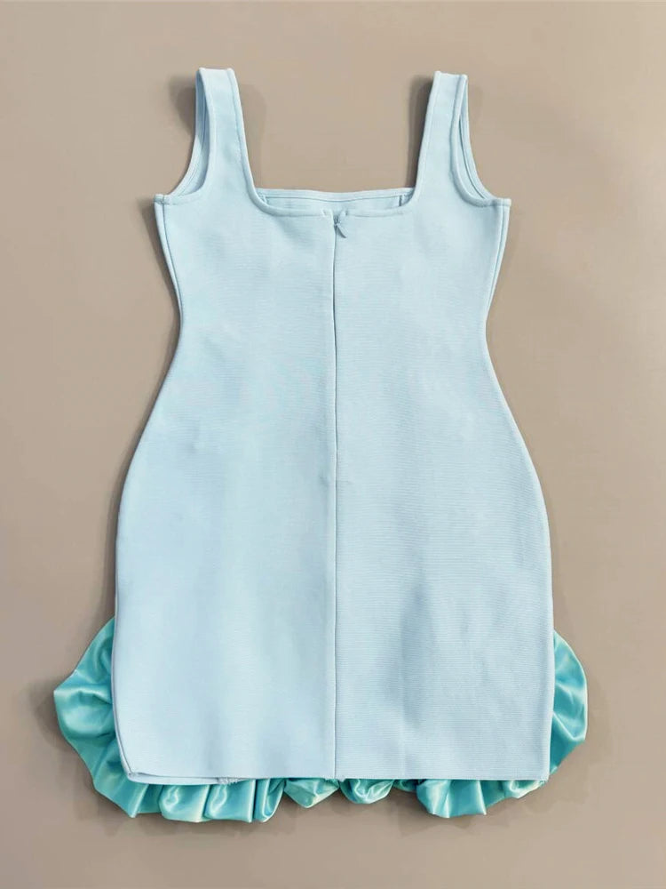 Light blue dress with ruffled hem on a beige background