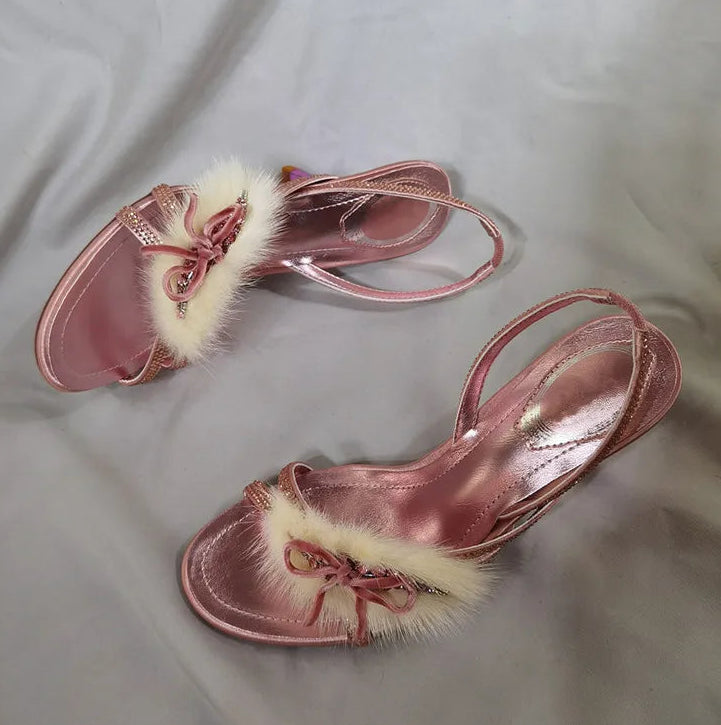 Pair of pink stiletto heels with faux fur and rhinestone details