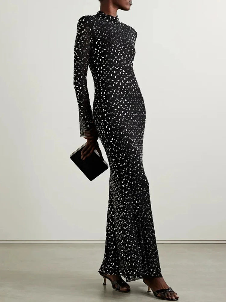 Crystal embellished turtleneck midi dress styled with a clutch.