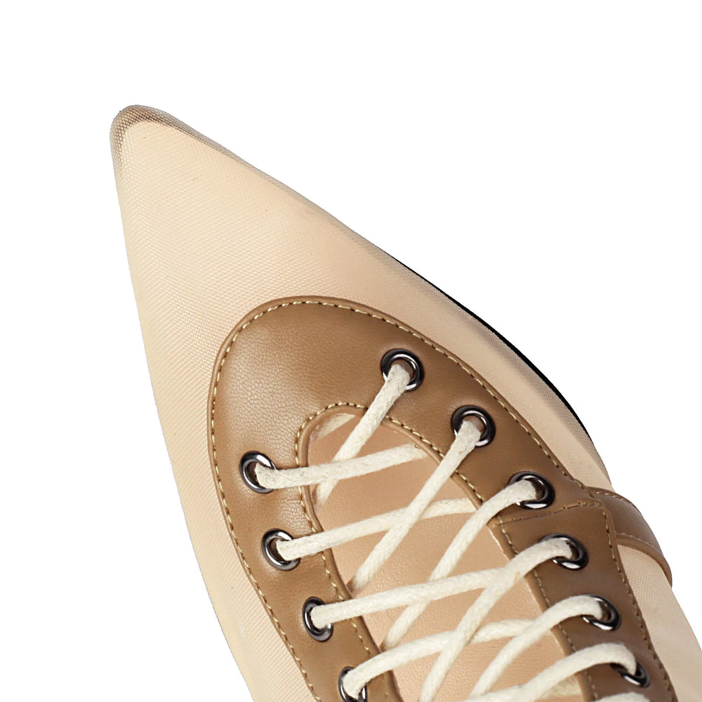 Close-up of a beige pointed-toe shoe with white laces