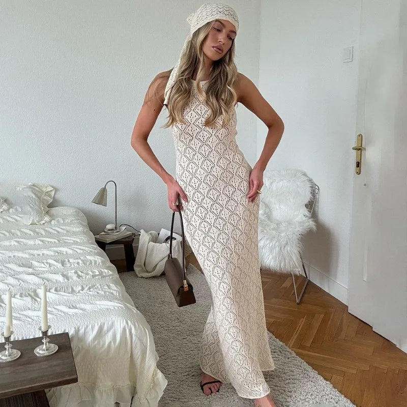 Woman in a white lace dress standing in a bedroom.