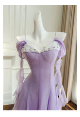 Close-up of the bodice on an off-shoulder gauze A-line midi dress with lace trim and chiffon sleeves.