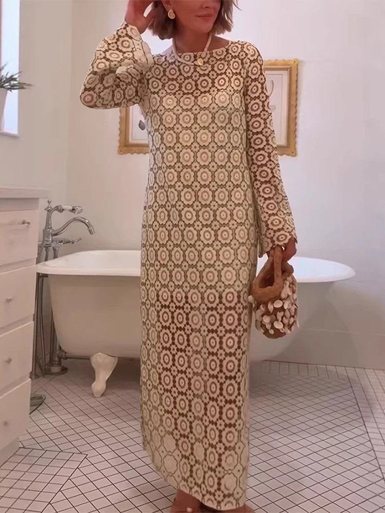 Woman in a patterned dress standing in a bathroom with a bathtub.