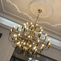 Chandelier illuminating a hotel lobby, creating a grand and luxurious atmosphere. Golden Atelier 4