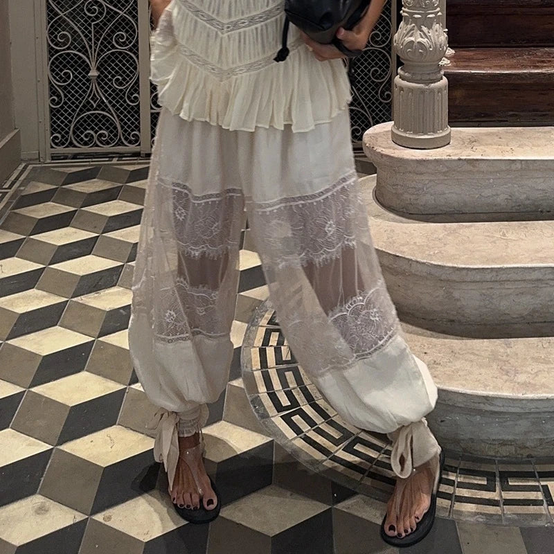 Person wearing a white lace dress standing on a checkered floor.