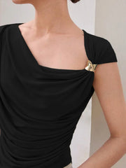Black draped top worn by a person on a plain background