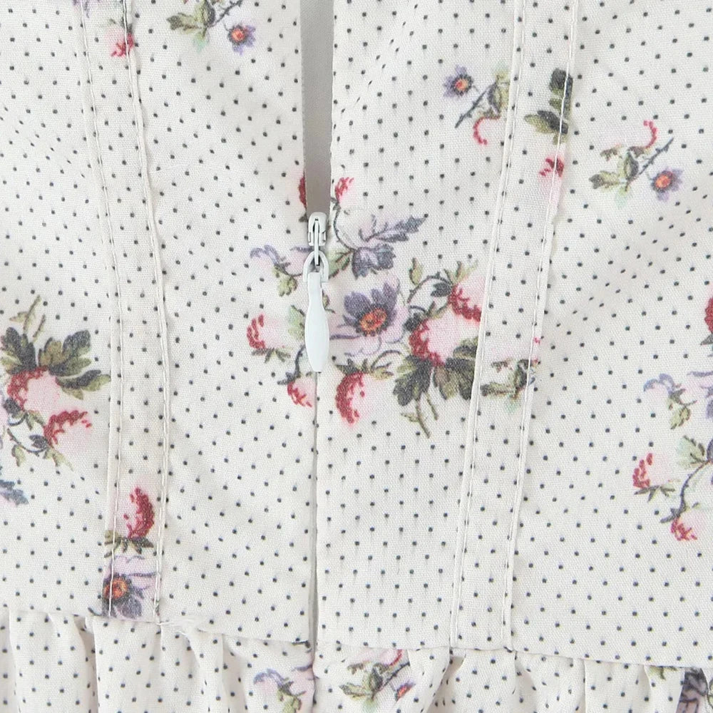 Floral patterned fabric with small black dots on a white background