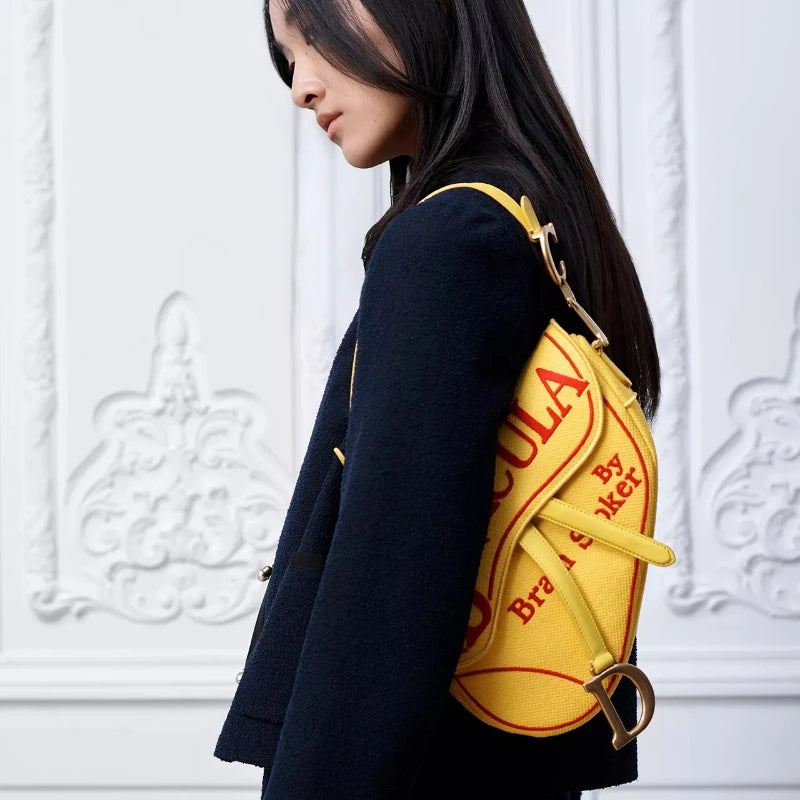 Model wearing a yellow saddle bag with red 'Dracula' print