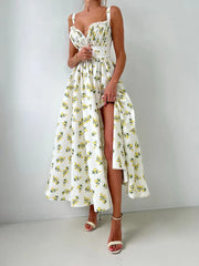 Woman wearing a floral dress with a high-low hem on a plain background