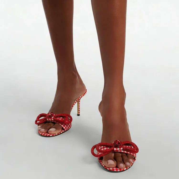 Red checkered high-heeled sandals with bow details on a white background